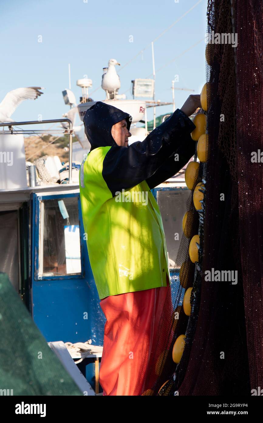 Tribunj, Croatie - 1er juillet 2021 : pêcheur travaillant dans un bateau de pêche fixant un filet de poisson Banque D'Images