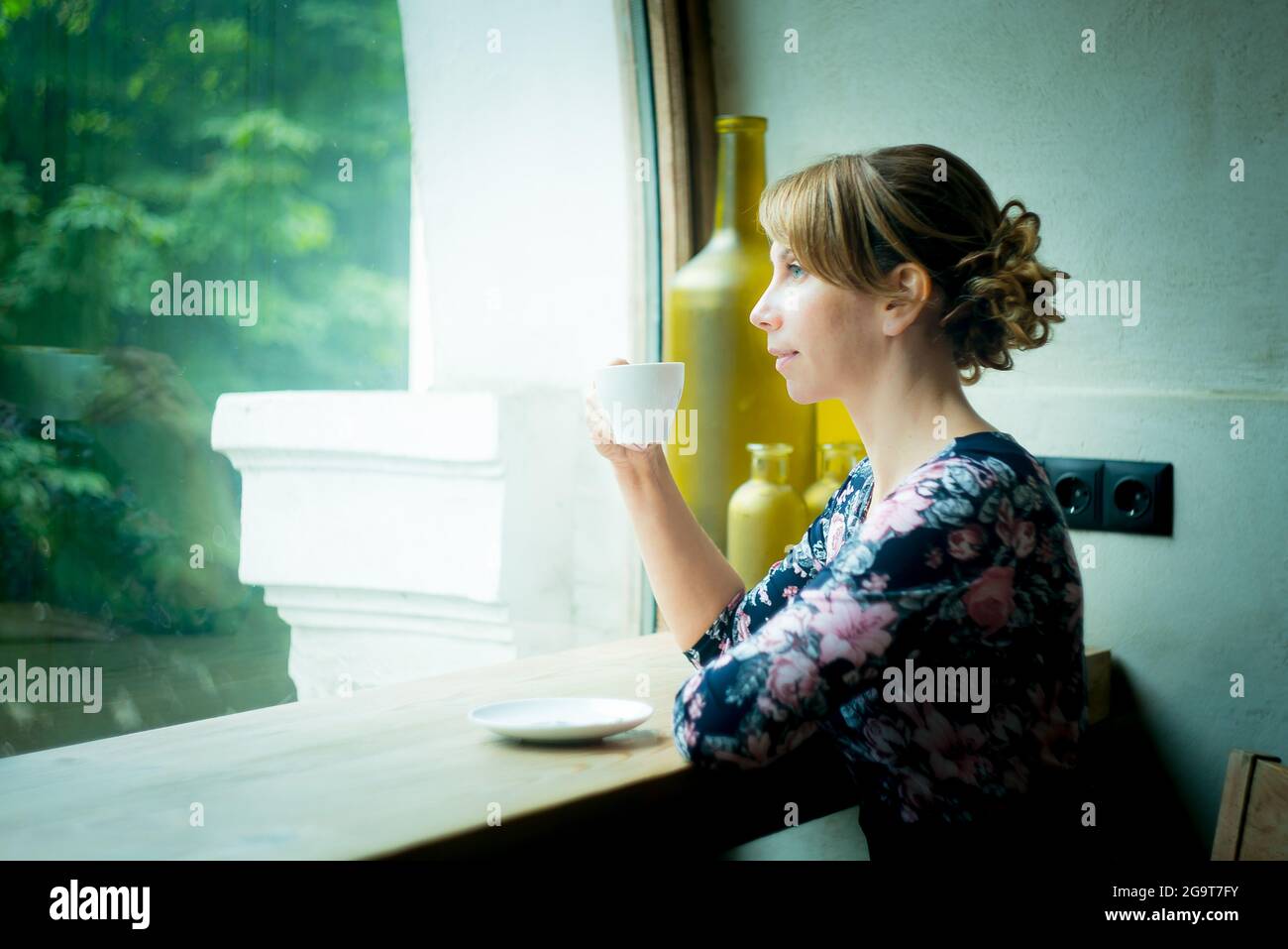 Le café du matin. Woman holding white tasse de café noir de s'asseoir près de la fenêtre. Jeune fille bénéficie d''un bain tonifiant café le matin Banque D'Images