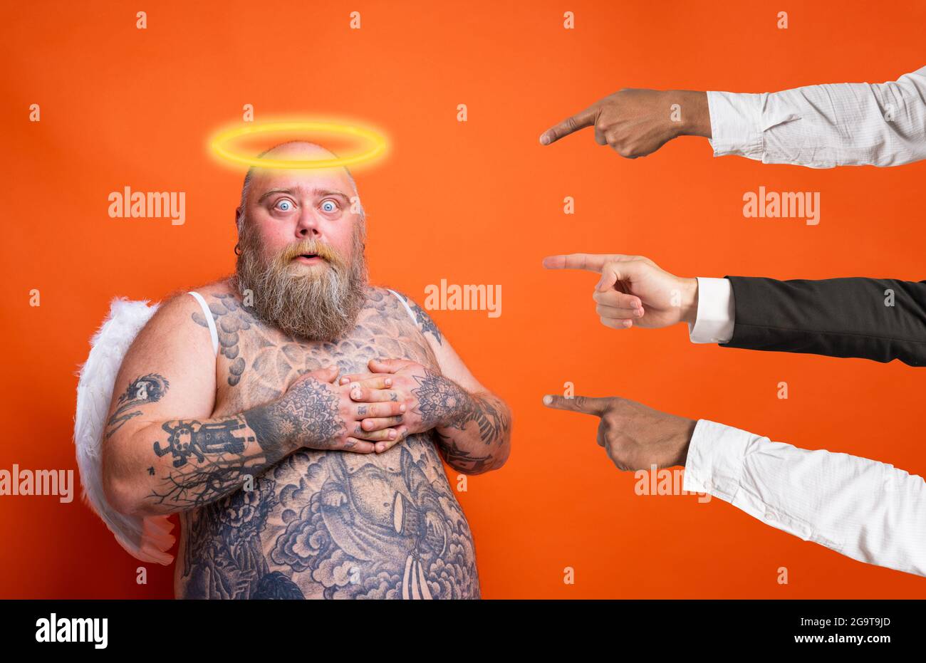 Gros homme peur avec la barbe, tatouages et ailes agit comme un ange Banque D'Images