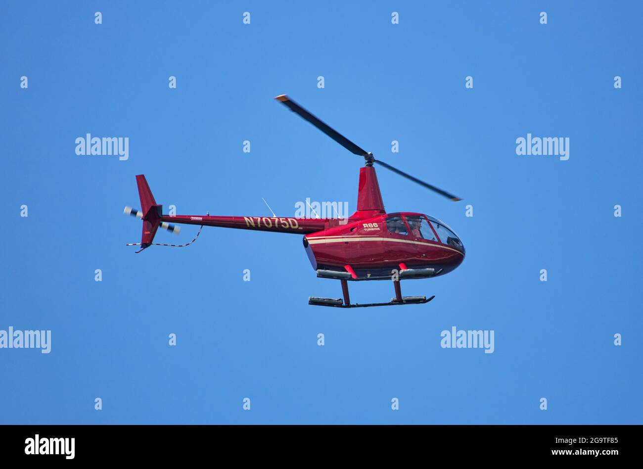 Un hélicoptère à turbine Robinson R66 est vu voler contre un ciel bleu  clair sans nuages Photo Stock - Alamy