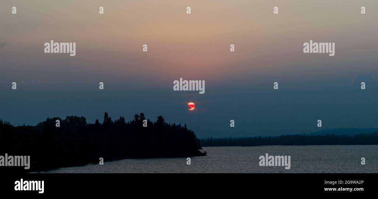 Coucher de soleil dans un ciel rempli de fumée. Banque D'Images