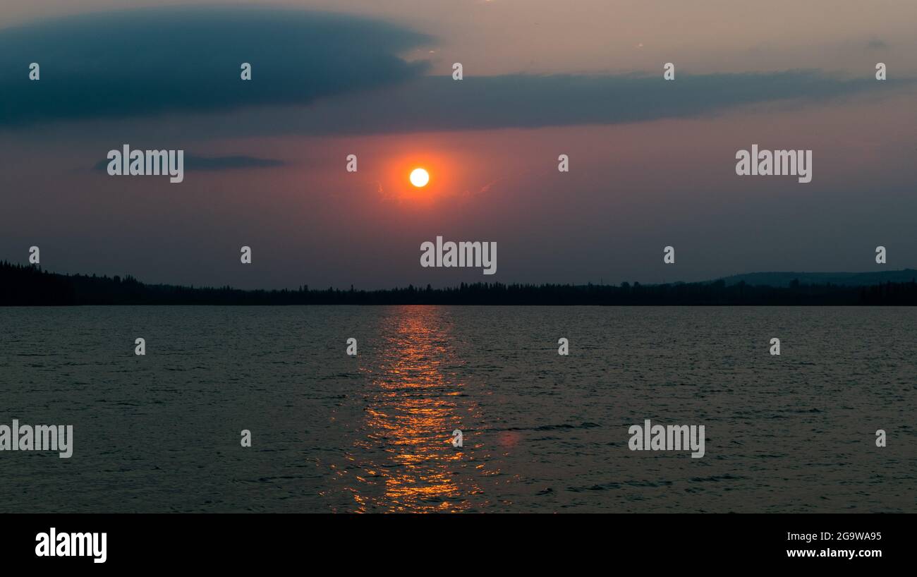 Coucher de soleil dans un ciel rempli de fumée. Banque D'Images