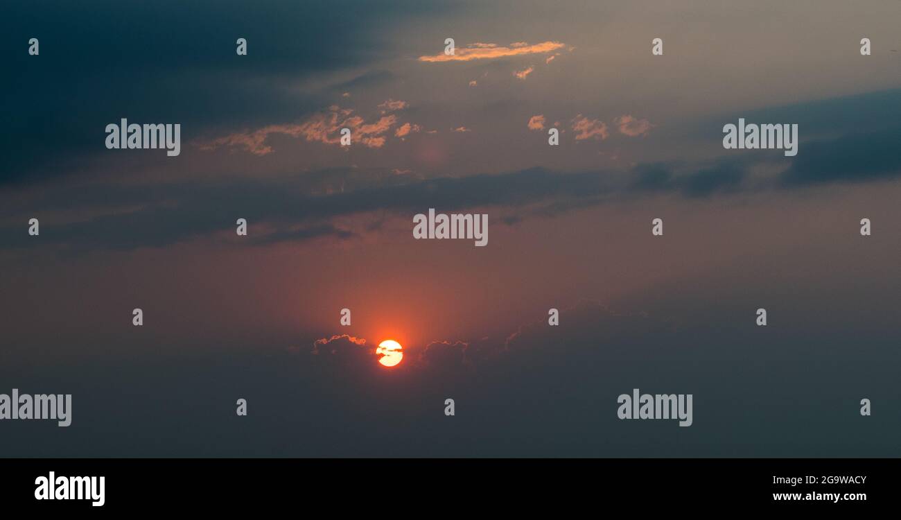 Coucher de soleil dans un ciel rempli de fumée. Banque D'Images