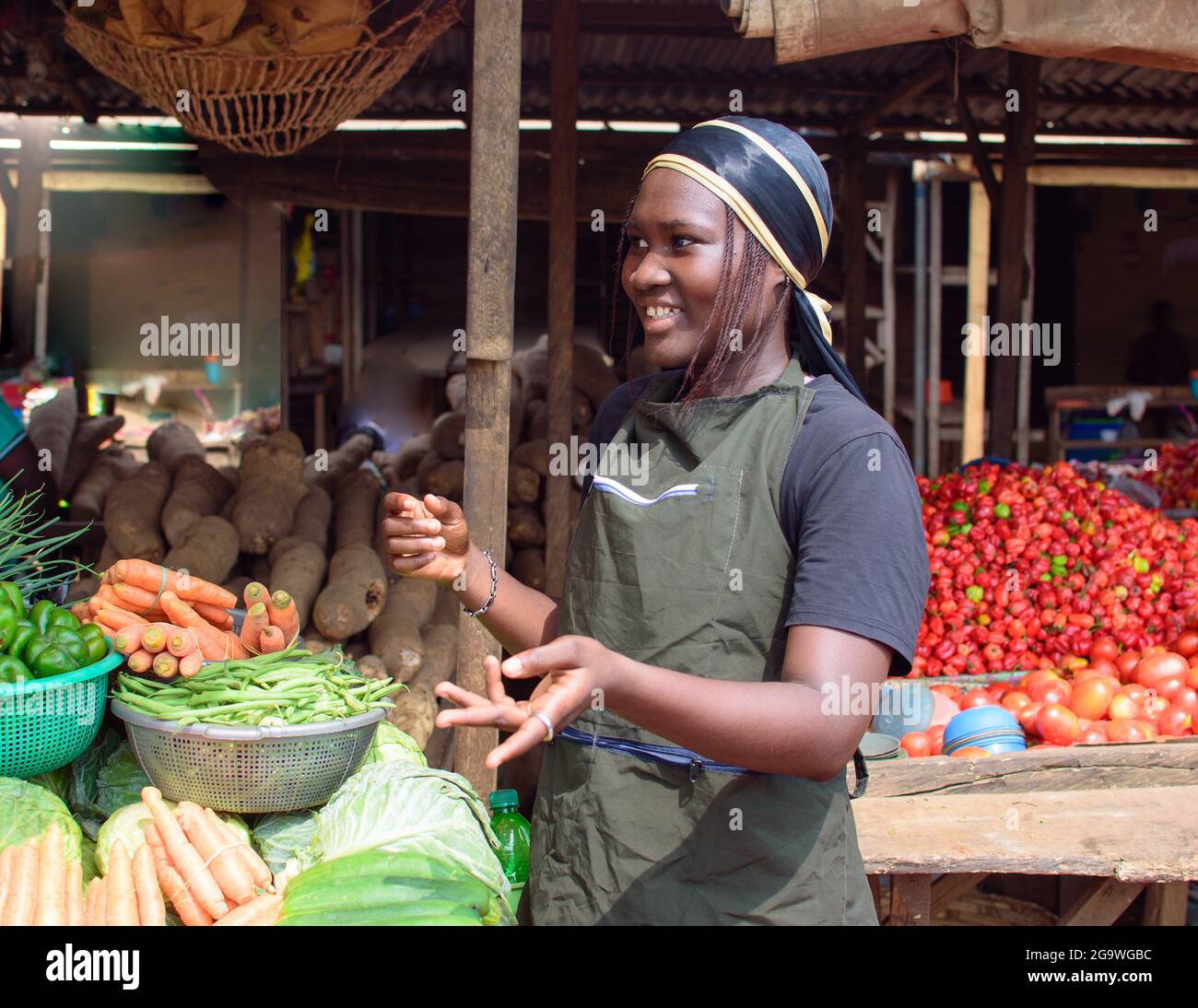 Photo de la vendeuse africaine d epicerie ou de la femme d affaires avec un tablier debout a sa stalle dans un marche prete a vendre a des clients Photo Stock Alamy