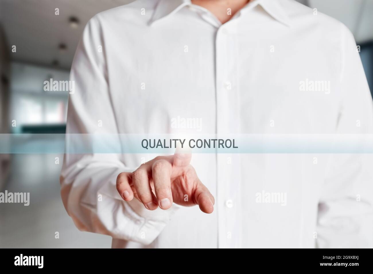 Homme d'affaires appuie sur le bouton de contrôle qualité sur un écran tactile virtuel. Concept de contrôle de la qualité de la production d'entreprise Banque D'Images