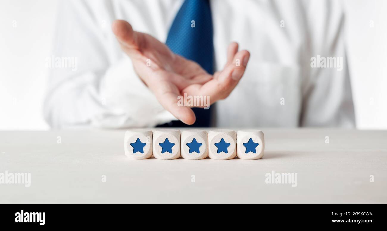 Main d'un homme d'affaires présentant les cubes en bois avec cinq symboles étoiles. Concept de satisfaction et d'évaluation des clients. Banque D'Images