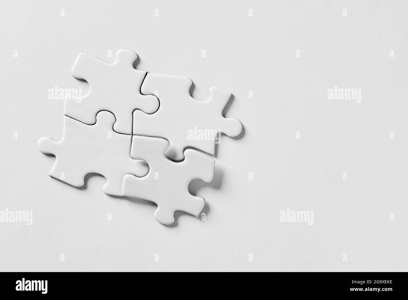 Quatre pièces de puzzle reliées les unes aux autres. Travail d'équipe, synergie, connexion, coopération, unité ou ensemble. Banque D'Images