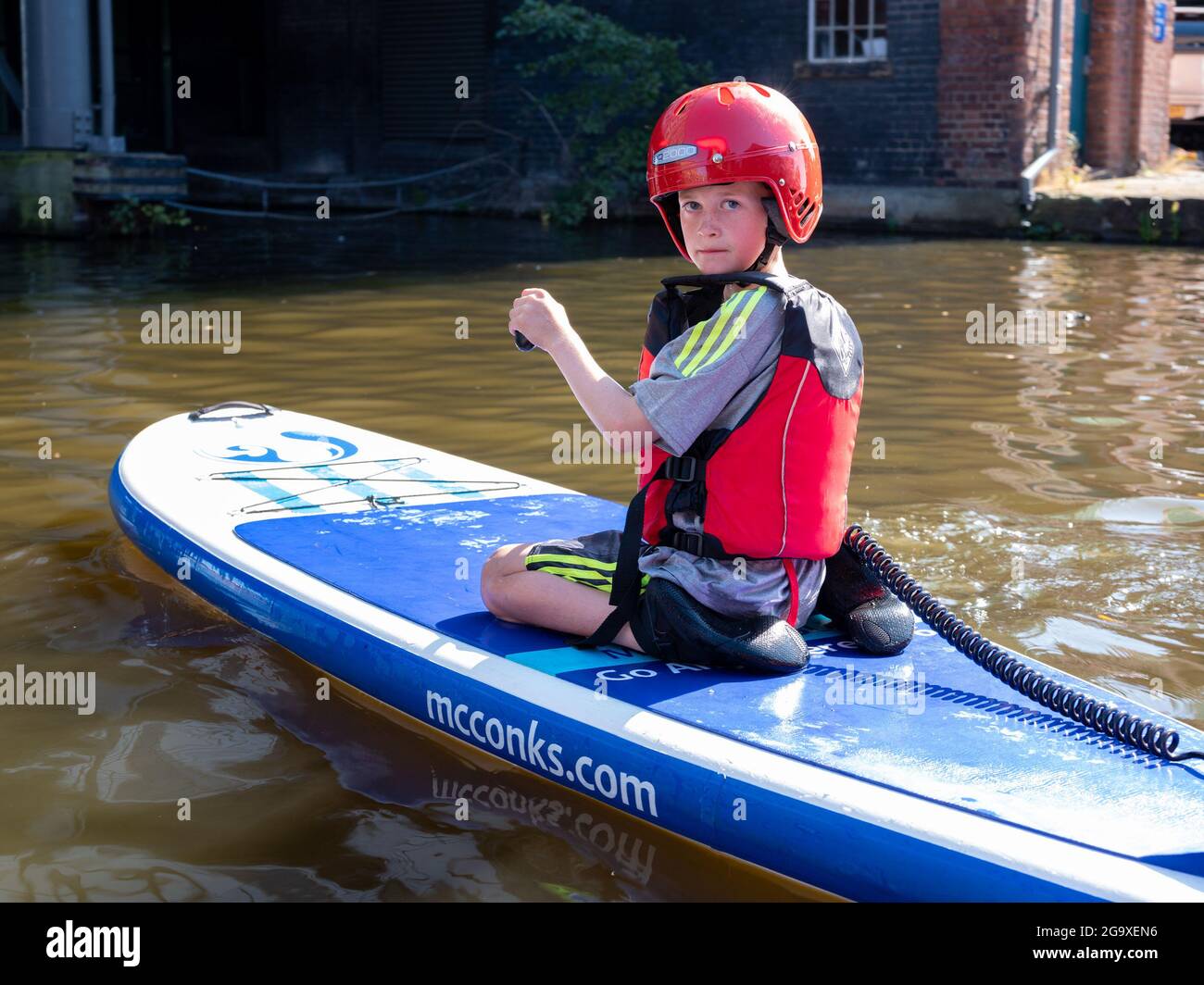 Garçon sur un paddle-board à Victoria Quay, au début du Sheffield et du canal Tinsley, Sheffield. Banque D'Images