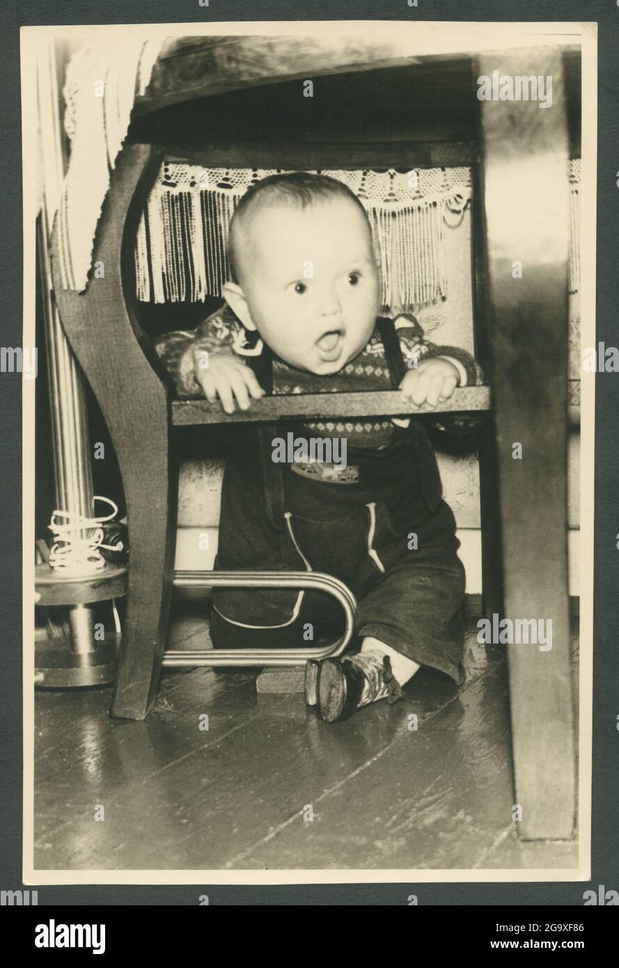 Europe, Allemagne, Hambourg, curiosité d'un petit garçon, assis sous une table, dans le 1950ème , INFO-DROITS-SUPPLÉMENTAIRES-HABILITATION-NON-DISPONIBLE Banque D'Images