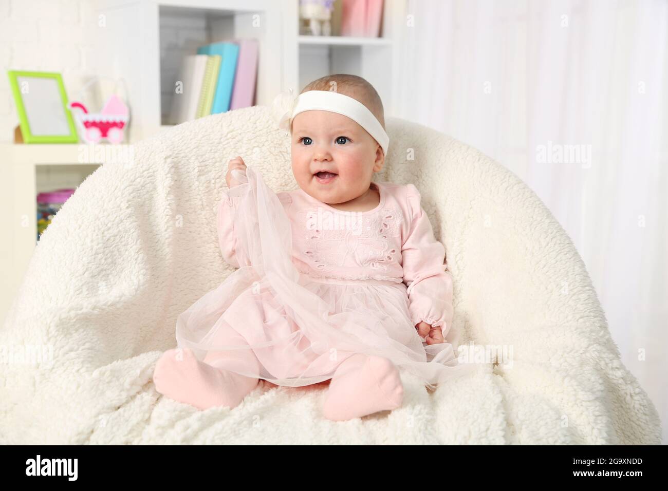Mignon Bebe Fille En Robe Rose Assis En Fauteuil Sur Fond D Interieur Accueil Photo Stock Alamy