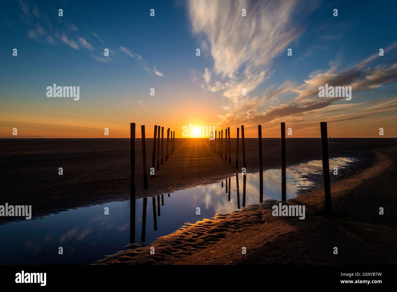 Poteaux en bois sur la plage au coucher du soleil, plage de Los Lances, Tarifa, province de Cadix, Andalousie, Espagne Banque D'Images