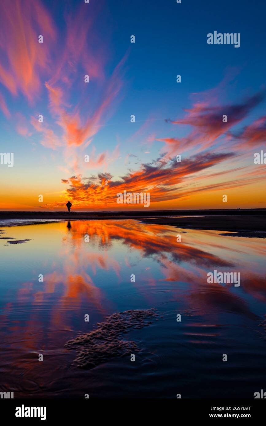 Vue arrière d'une personne se tenant sur la plage au coucher du soleil, plage de Los Lances, Tarifa, province de Cadix, Andalousie, Espagne Banque D'Images