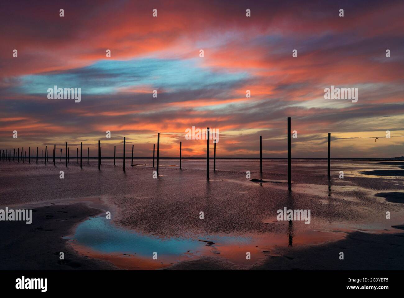 Poteaux en bois sur la plage au coucher du soleil, plage de Los Lances, Tarifa, Cadix, Andalousie, Espagne Banque D'Images