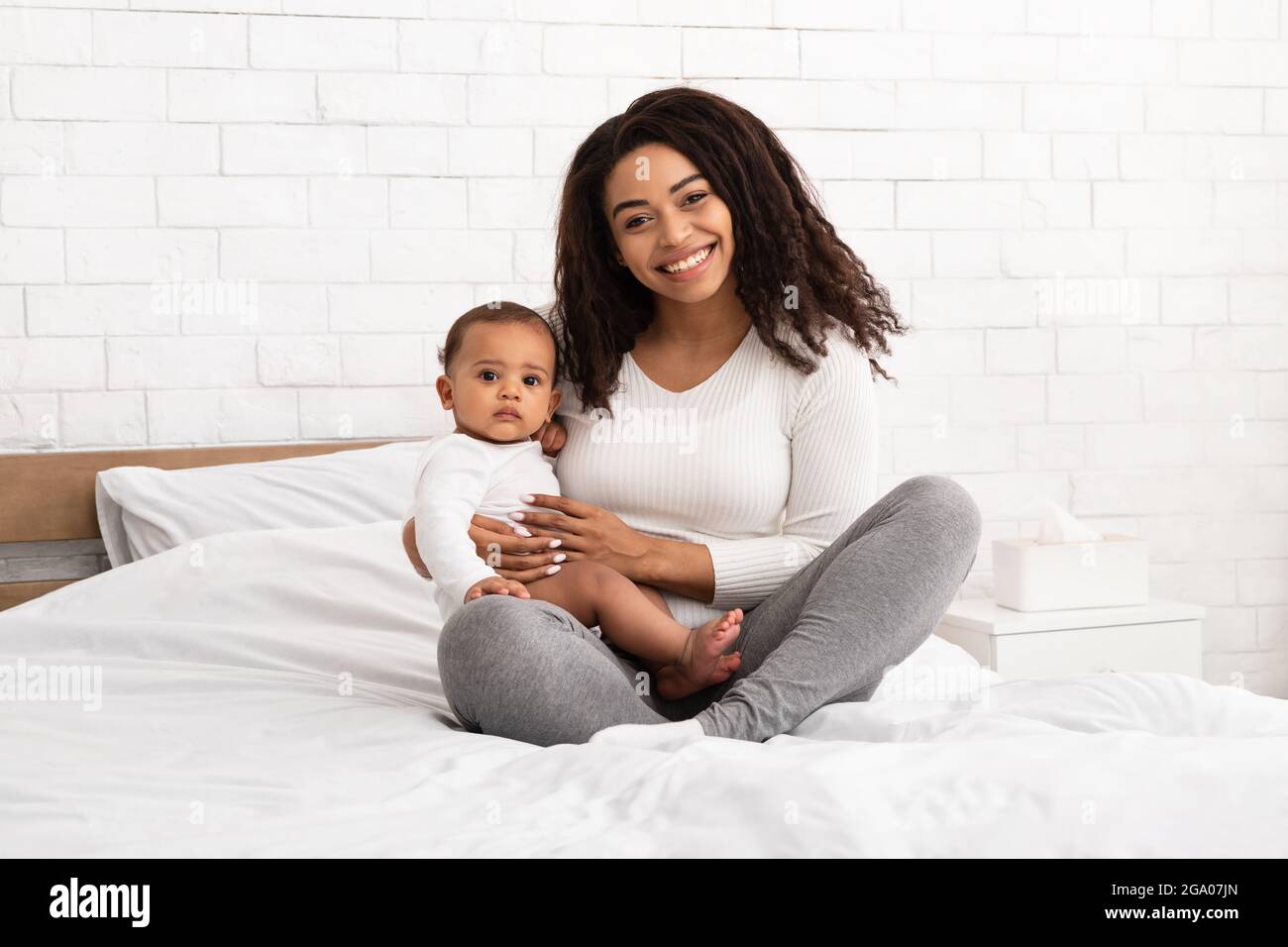 Bonne mère afro-américaine embrassant bébé garçon intérieur Banque D'Images
