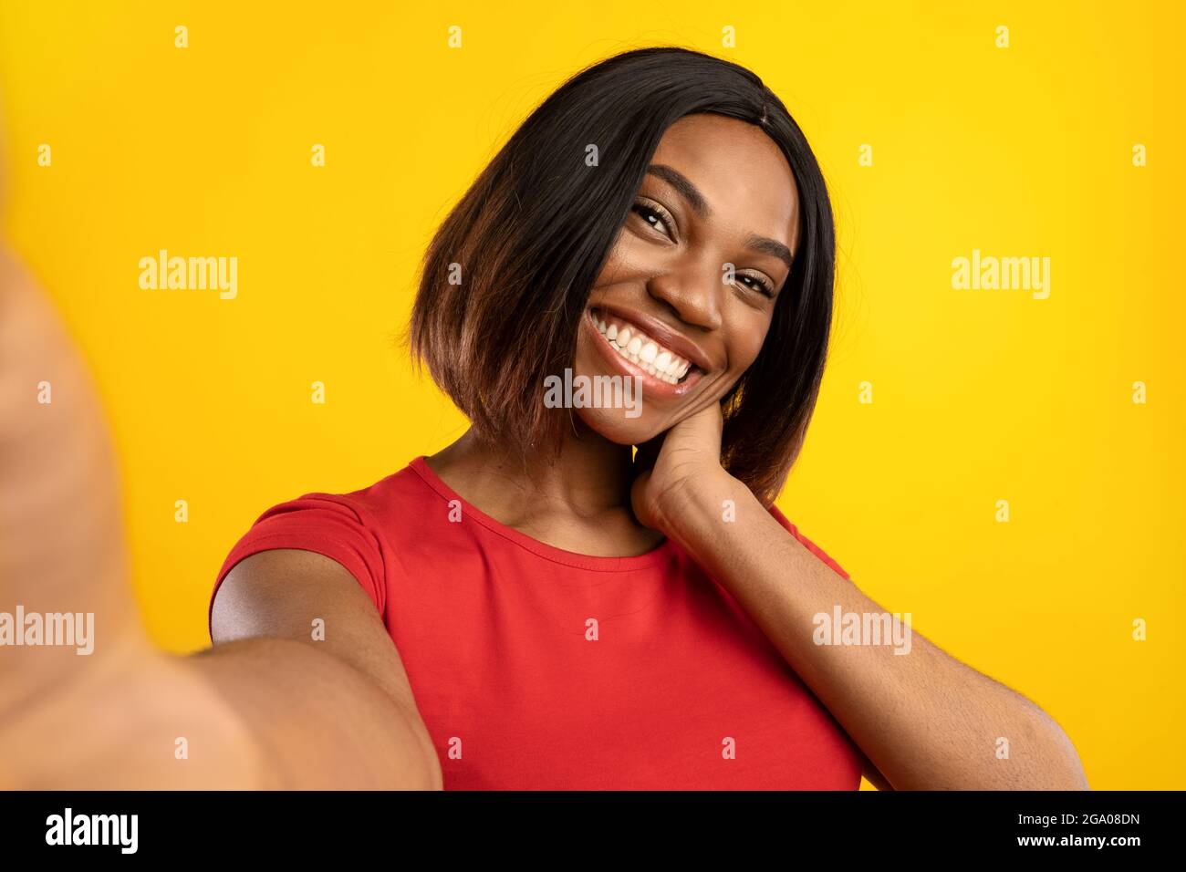 Afro-américain Blogger Lady faisant Selfie posant sur fond jaune Banque D'Images
