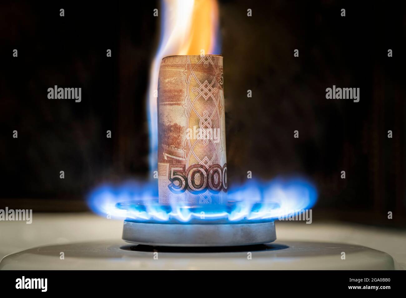 Le rouble russe brûle dans le feu. Concept la hausse du prix du gaz en Russie. Une facture de 5000 roubles brûle dans un feu sur un poêle à gaz. Cher Banque D'Images