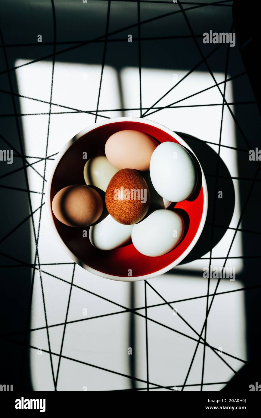 Vue en hauteur sur les œufs aux couleurs vives dans un bol rouge Banque D'Images