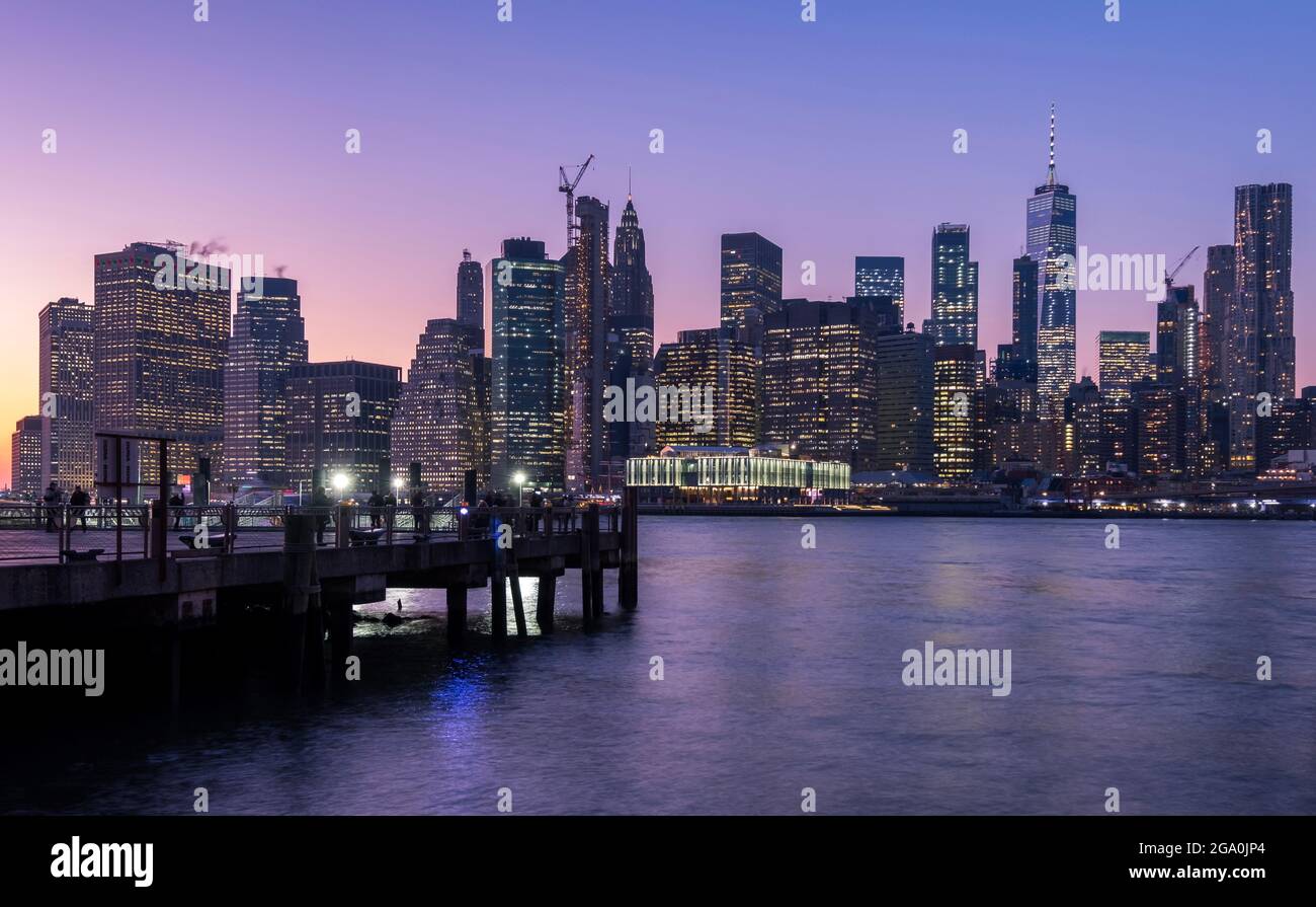 Lorsque le soleil se couche, la ville de Manhattan commence à briller et affiche toutes ses couleurs, vues de la région de D.U.M.B.O..New York City, États-Unis Banque D'Images
