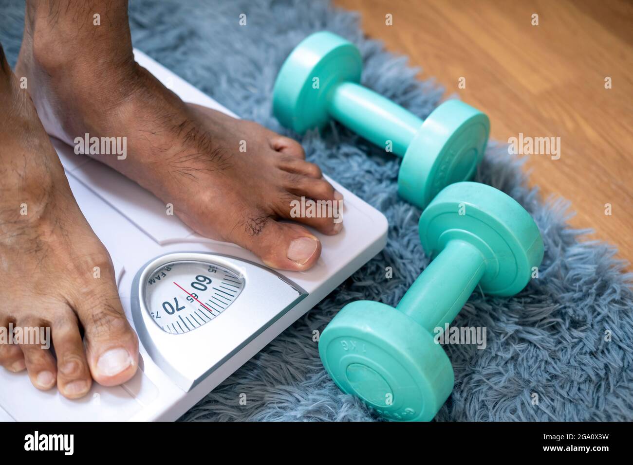 Homme de pied asiatique avec balance de poids pour mesurer la perte de poids.balance à un concept d'amincissement sain Banque D'Images