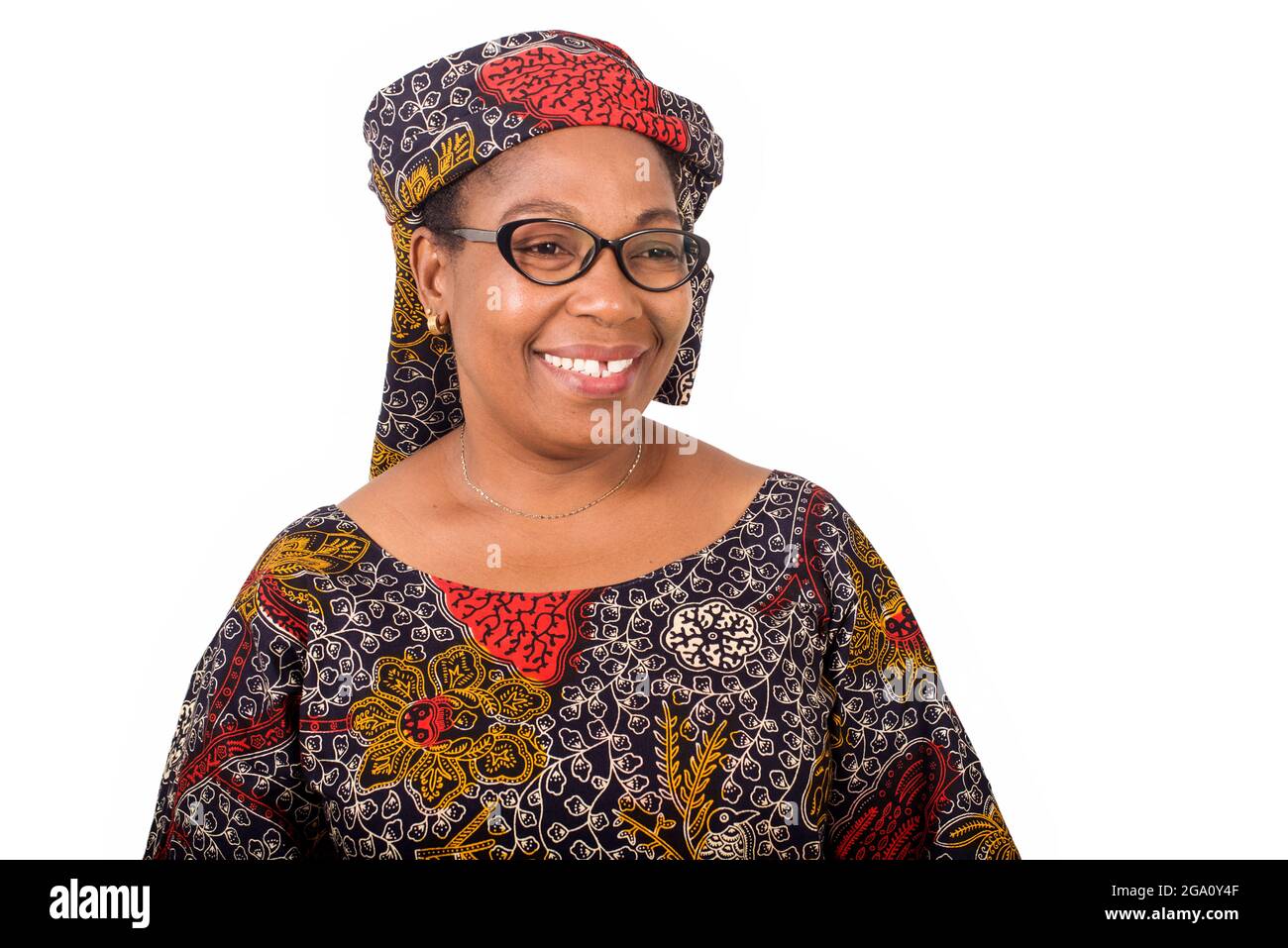 femme africaine mûre en toile de longe debout sur fond blanc regardant l'appareil-photo sourire. Banque D'Images