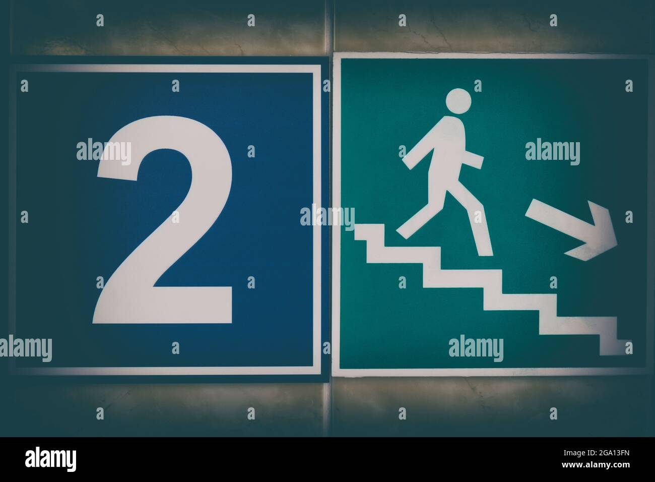 Signes stylisés 'sortie d'évacuation' avec la figure d'un petit homme blanc et 'numéro deux' avec vignette Banque D'Images