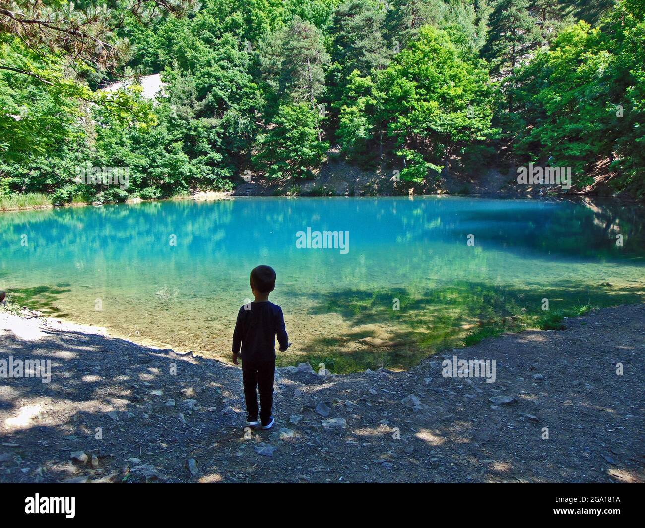 Un garçon regarde le lac bleu à Baia Sprie, Maramures Banque D'Images