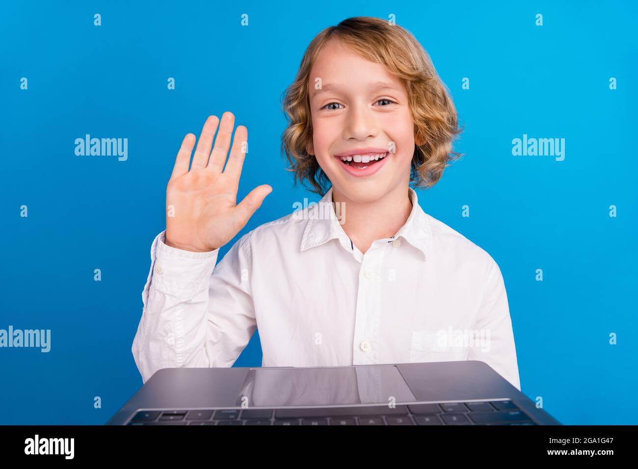 Portrait d'un beau garçon tendance et joyeux qui fait un appel vidéo tout  en saluant le salut isolé sur fond bleu vif Photo Stock - Alamy