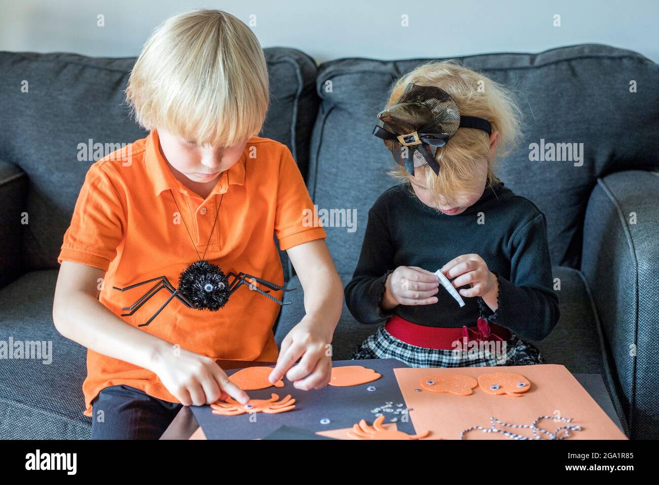 Petits enfants faisant l'artisanat d'Halloween à la maison, portant des costumes de vacances Banque D'Images