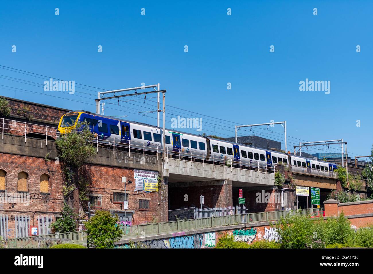 train sur une ligne sur un viaduc de remblai construit en brique rouge dans le centre de manchester royaume-uni. les chemins de fer de manchester et la ligne de transport public en béton. Banque D'Images