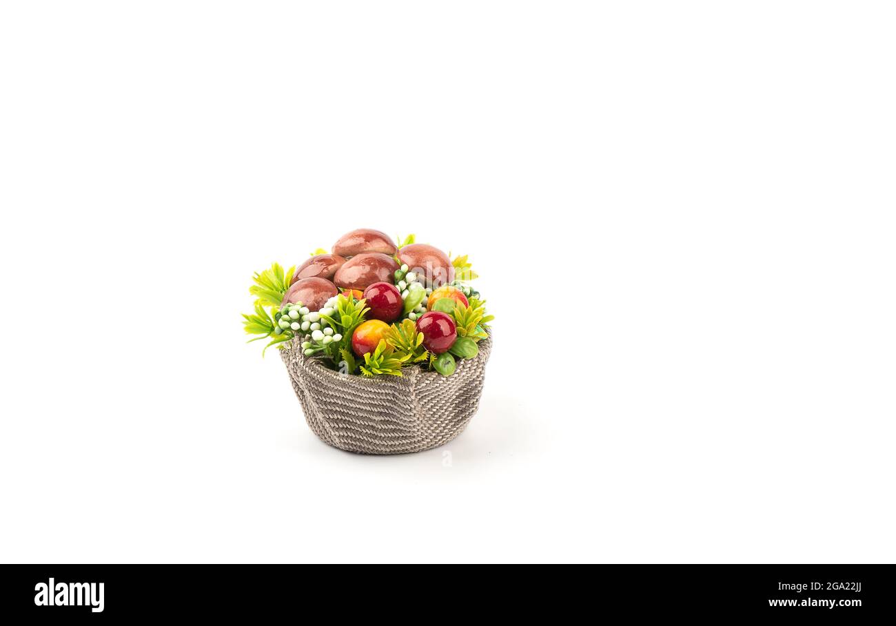 Champignons artificiels et fleurs dans un panier avec toile de jute. Panier de champignons et de lichen de renne sur fond blanc avec place pour le texte. Banque D'Images
