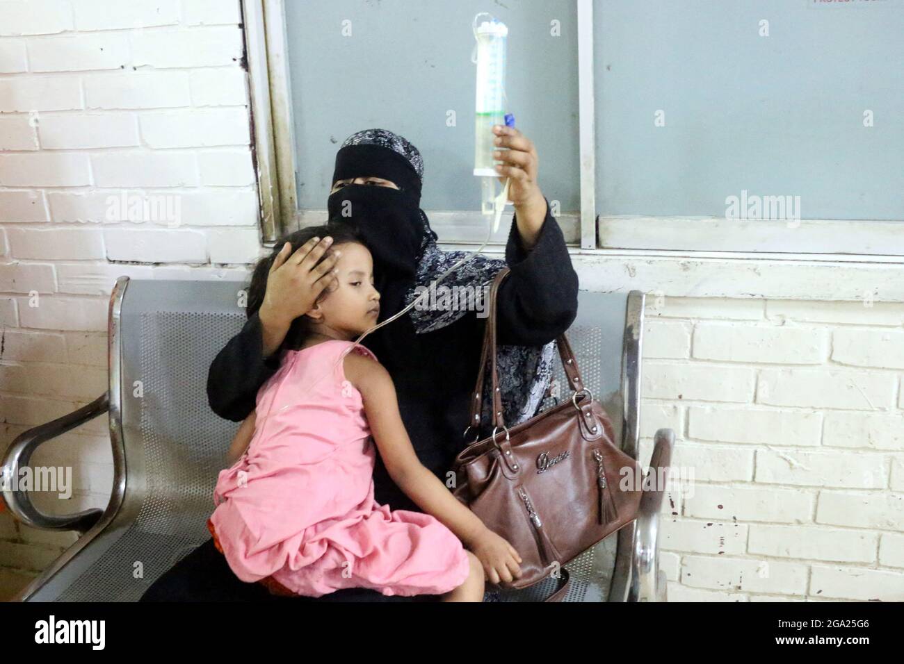 Une personne tient son enfant pendant qu'elle attend que sa fille soit fréquentée à l'hôpital pour enfants, car elle a été infectée par une nouvelle épidémie de dengue le 28 juillet 2021 à Dhaka, au Bangladesh. Photo de Habibur Rahman/Eyepix/ABACAPRESS.COM Banque D'Images