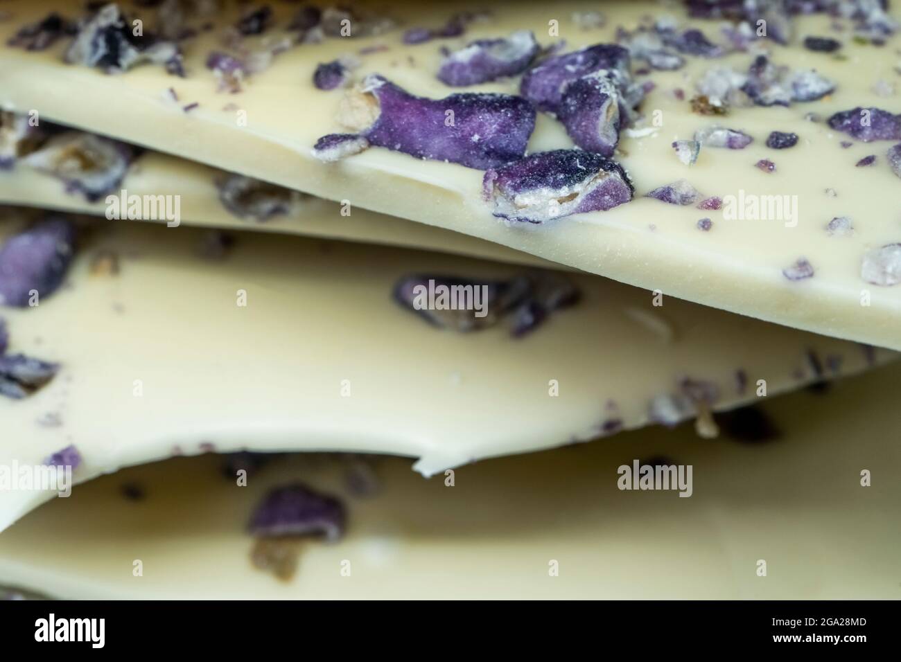 Meilleure tuile de chocolat blanc avec pistache et violet. Arrière-plan blanc, gros plan. Photo de haute qualité Banque D'Images