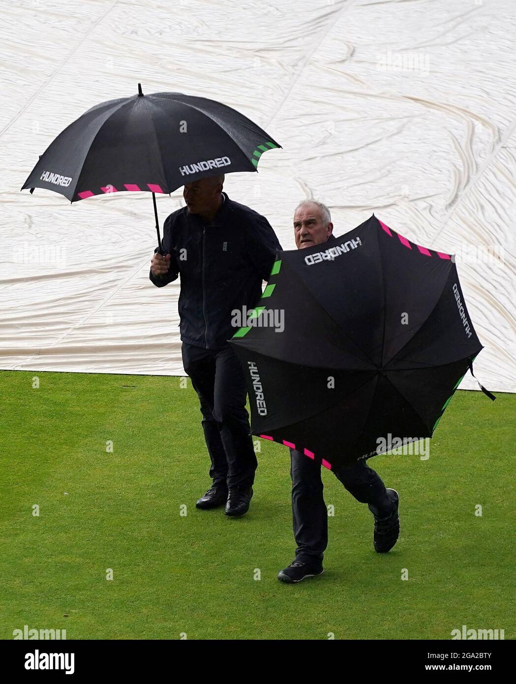 Les arbitres Peter Hartley (à droite) et Graham Lloyd sur le terrain avant d'abandonner la structure en raison de la pluie pendant le match des cent au Emirates Old Trafford, Manchester. Date de la photo: Mercredi 28 juillet 2021. Banque D'Images