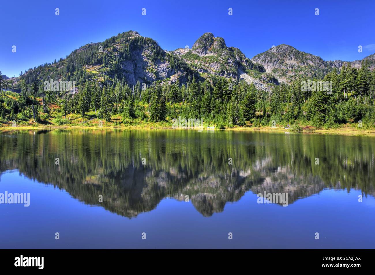 Image miroir des montagnes et du ciel bleu vif se reflétant dans un lac, le Mount Baker National Recreation Area; Washington, États-Unis d'Amérique Banque D'Images