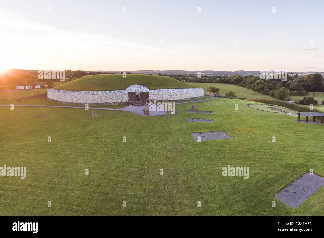 Vue aérienne d'un coucher de soleil sur l'ancien tombeau de passage et le temple de Newgrange, un monument néolithique du site du patrimoine de Bru na Boinne Banque D'Images