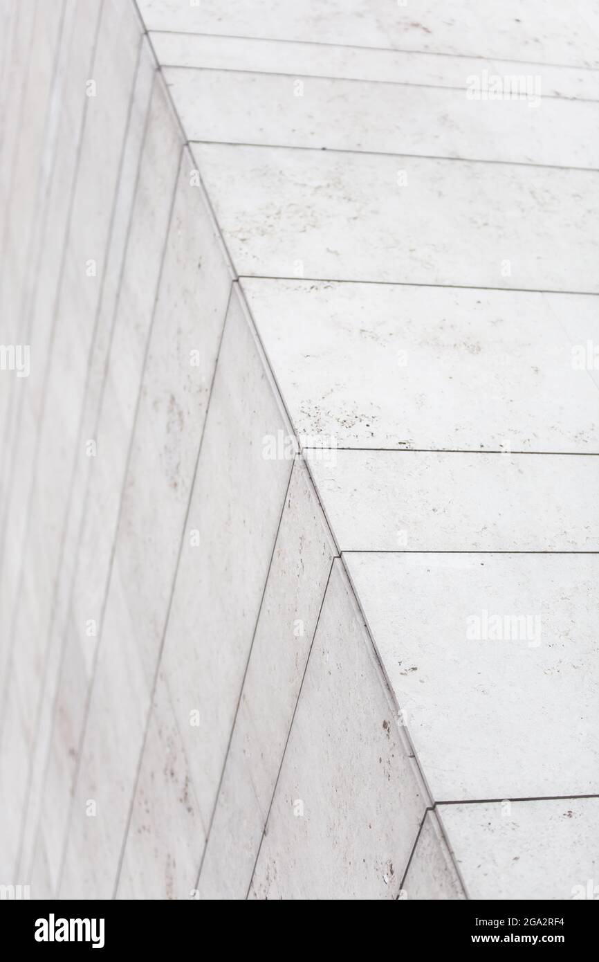 Surface murale minimaliste en marbre blanc avec carreaux et lignes parallèles. Simplicité dans une architecture moderne. Coins et arêtes vives Banque D'Images