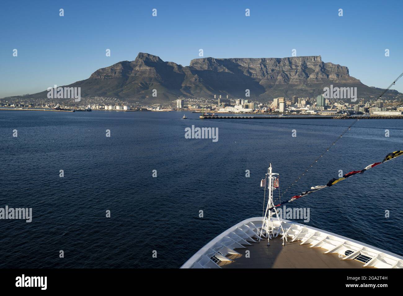 Gros plan de l'arc d'un navire dans la baie de Table en regardant vers le port de Cape Town et le majestueux Devil's Peak et la montagne de Table qui s'élève au-dessus de la ... Banque D'Images