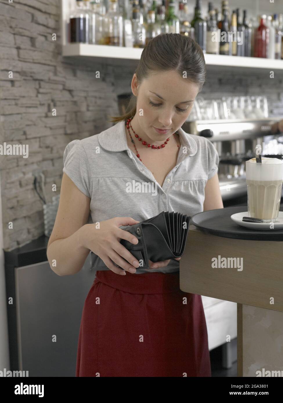 Jeune femme travaillant dans un restaurant; Allemagne Banque D'Images