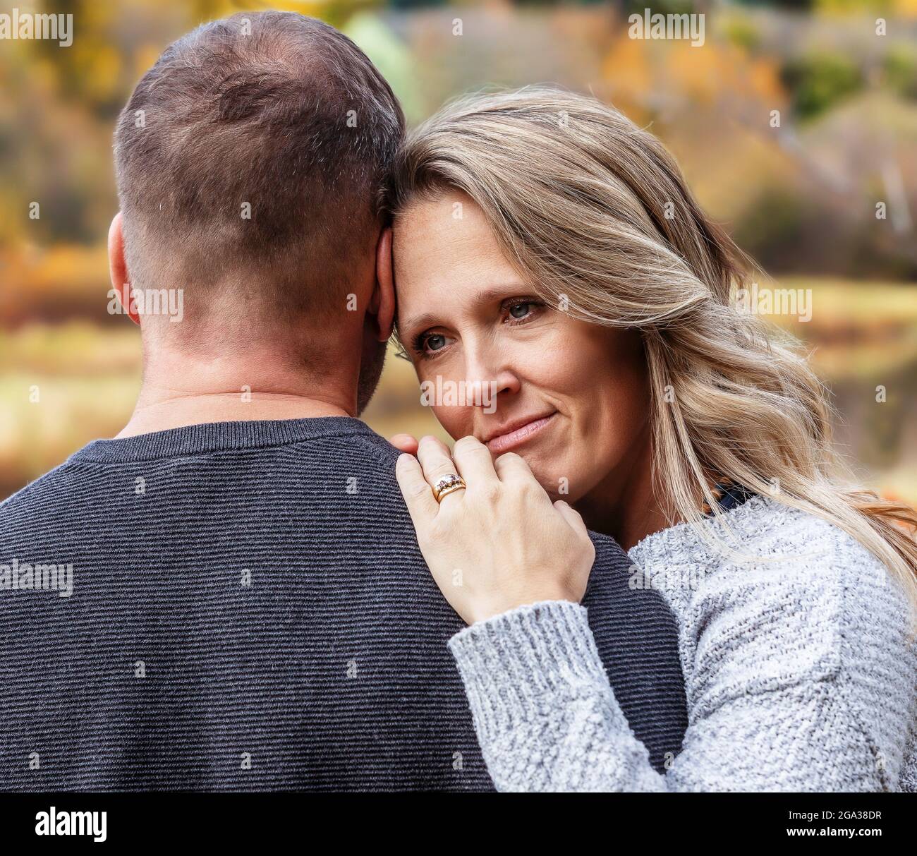 Un couple marié qui passe du temps ensemble de qualité à l'extérieur dans un parc de la ville pendant un après-midi d'automne chaud; St. Albert, Alberta, Canada Banque D'Images