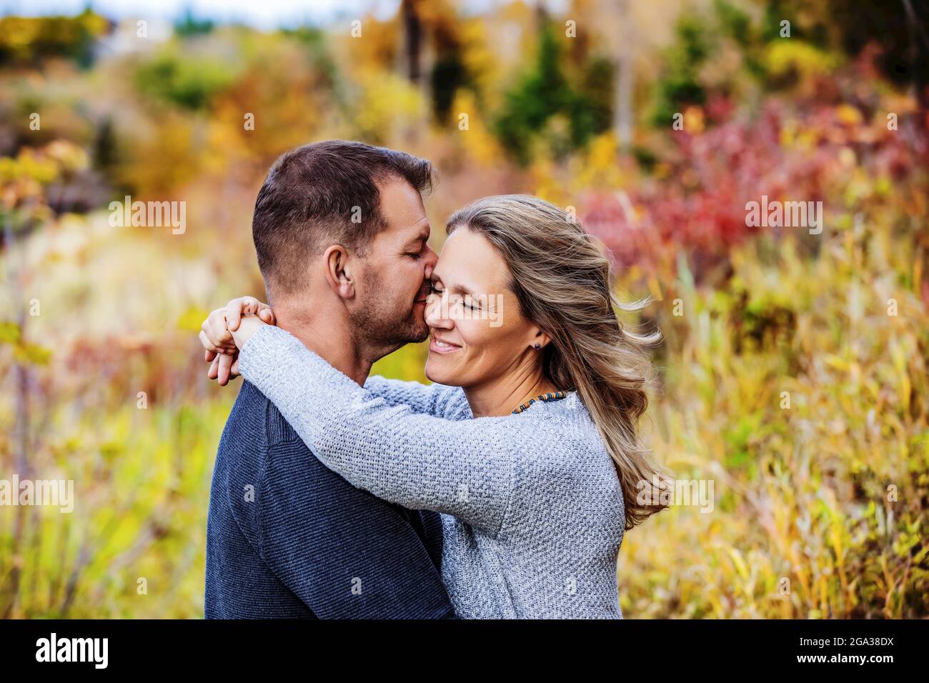 Un couple marié qui passe du temps ensemble de qualité à l'extérieur dans un parc de la ville pendant un après-midi d'automne chaud; St. Albert, Alberta, Canada Banque D'Images