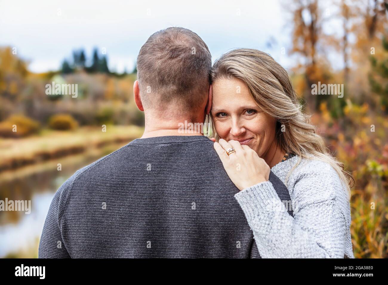 Un couple marié qui passe du temps ensemble de qualité à l'extérieur dans un parc de la ville pendant un après-midi d'automne chaud; St. Albert, Alberta, Canada Banque D'Images