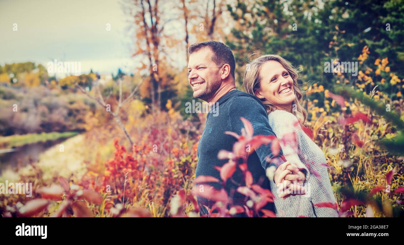 Un couple marié qui passe du temps ensemble de qualité à l'extérieur dans un parc de la ville pendant un après-midi d'automne chaud; St. Albert, Alberta, Canada Banque D'Images