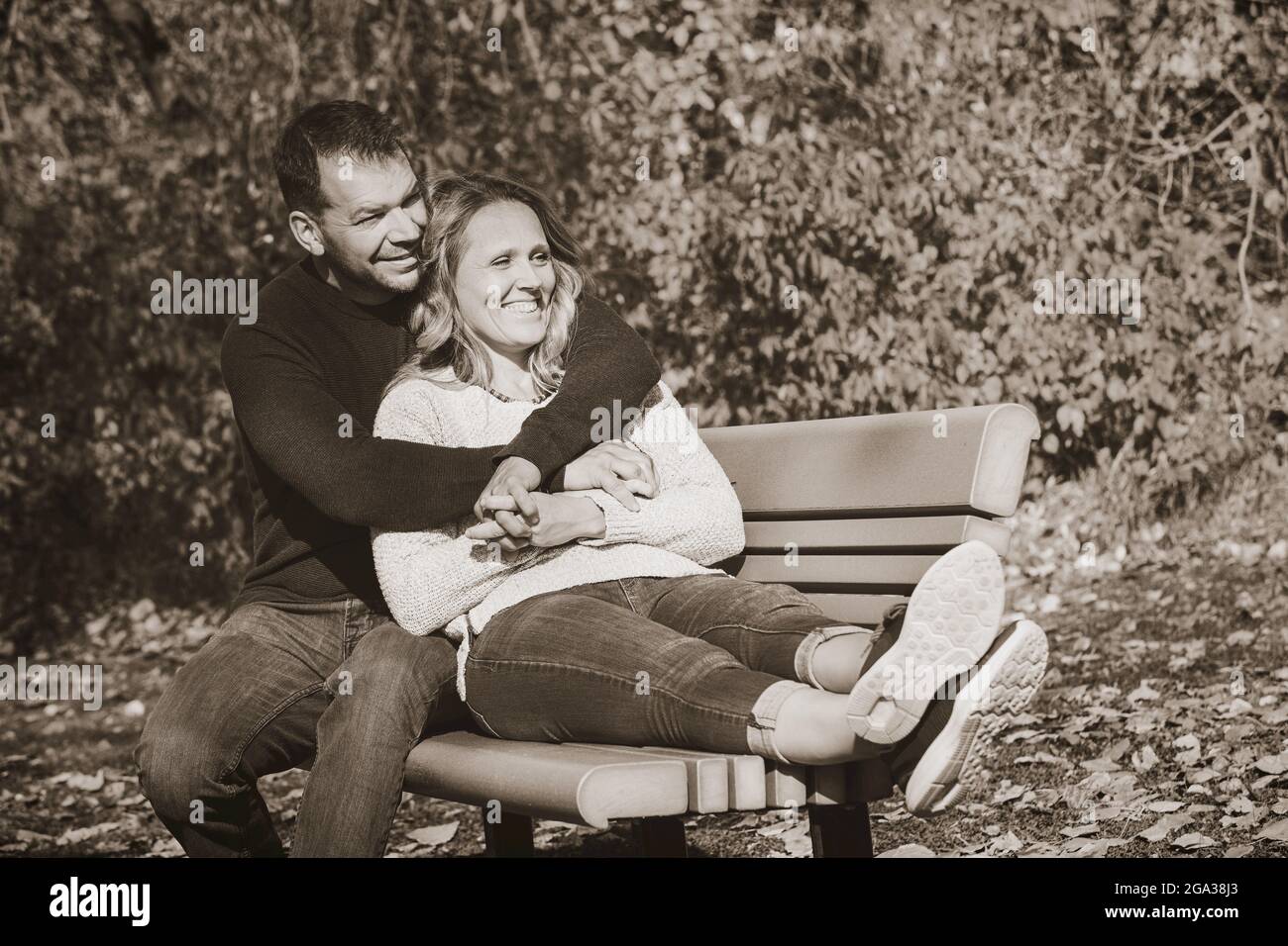 Un couple marié qui passe du temps ensemble de qualité à l'extérieur dans un parc de la ville pendant un après-midi d'automne chaud; St. Albert, Alberta, Canada Banque D'Images