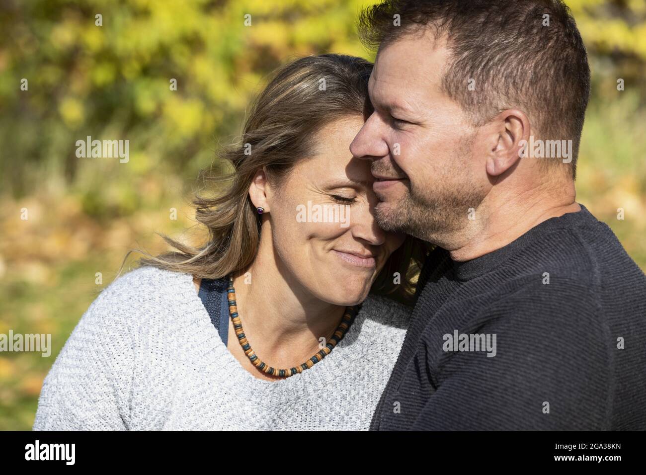 Un couple marié qui passe du temps ensemble de qualité à l'extérieur dans un parc de la ville pendant un après-midi d'automne chaud; St. Albert, Alberta, Canada Banque D'Images