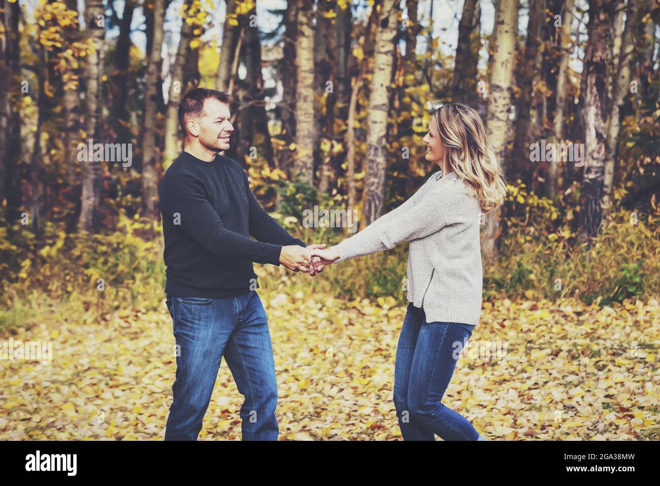 Un couple marié qui passe du temps ensemble de qualité et danse ensemble à l'extérieur dans un parc municipal pendant la saison d'automne; St. Albert, Alberta, Canada Banque D'Images