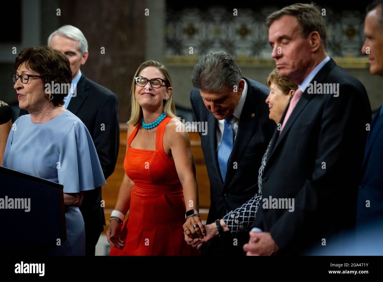 Le sénateur américain Kyrsten Sinema (démocrate de l’Arizona), à gauche, s’empresse de tenir la main de la sénatrice américaine Jeanne Shaheen (démocrate du New Hampshire) tandis que la sénatrice américaine Susan Collins (républicaine du Maine), à gauche, Fait des remarques après le vote sur la motion d'invoquer le cloture pour procéder à l'étude de H.R. 3684, la loi INVEST in America sur Capitol Hill à Washington, DC, le mercredi 28 juillet 2021. Le vote pour entamer la discussion sur le projet de loi bipartisan sur les infrastructures adopté par la Maison Blanche a été de 67 à 32. Si elle était adoptée, la loi investirait près de mille milliards de dollars en ro Banque D'Images