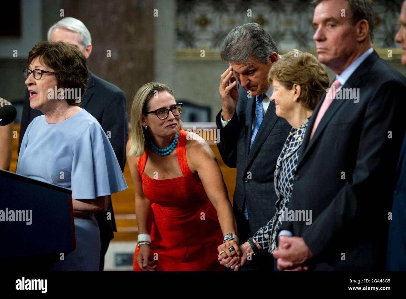 Le sénateur américain Kyrsten Sinema (démocrate de l’Arizona), à gauche, s’empresse de tenir la main de la sénatrice américaine Jeanne Shaheen (démocrate du New Hampshire) tandis que la sénatrice américaine Susan Collins (républicaine du Maine), à gauche, Fait des remarques après le vote sur la motion d'invoquer le cloture pour procéder à l'étude de H.R. 3684, la loi INVEST in America sur Capitol Hill à Washington, DC, le mercredi 28 juillet 2021. Le vote pour entamer la discussion sur le projet de loi bipartisan sur les infrastructures adopté par la Maison Blanche a été de 67 à 32. Si elle était adoptée, la loi investirait près de mille milliards de dollars en ro Banque D'Images