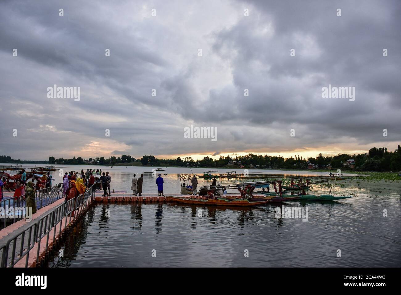 Cachemire, Inde. 28 juillet 2021. Les visiteurs marchent sur la jetée près du lac Mansbal lors d'une journée nuageux à Manasbal, à environ 30 km de Srinagar. Le Département météorologique de l'Inde a publié mercredi une alerte météorologique pour Jammu-et-Cachemire, prédisant des pluies abondantes qui peuvent causer des inondations soudaines, des glissements de terrain et aussi l'exploitation forestière de l'eau dans les zones de basse altitude. Au moins sept personnes ont été tuées et 19 sont restées disparues après des inondations soudaines qui ont frappé Jammu et Kashmirís, le district montagneux reculé de Kishtwar, suite à une explosion de nuages mercredi. Crédit : SOPA Images Limited/Alamy Live News Banque D'Images