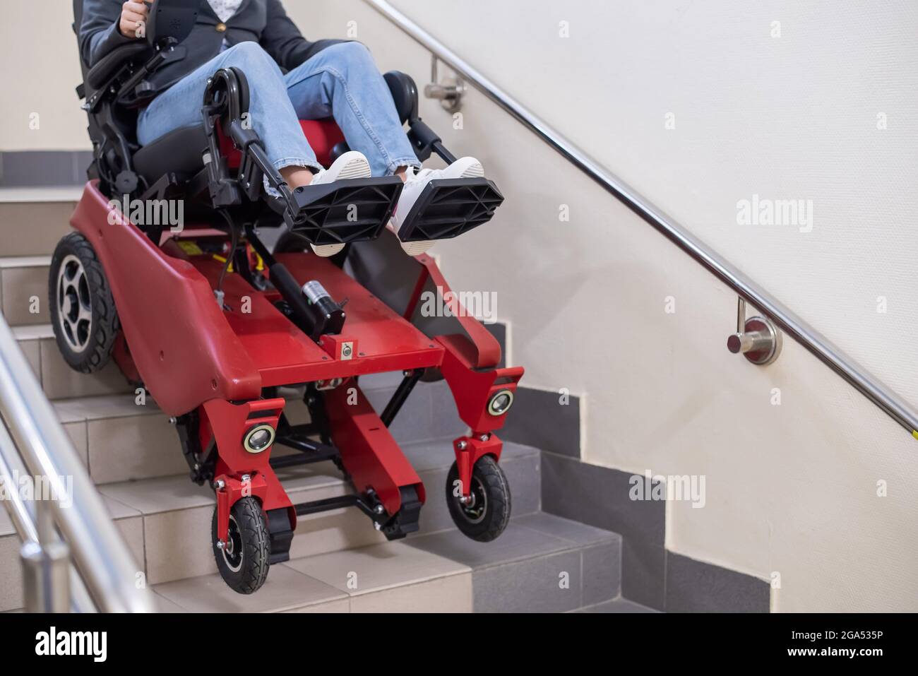Femme caucasienne en fauteuil roulant avec chenille électrique descendant  les escaliers Photo Stock - Alamy