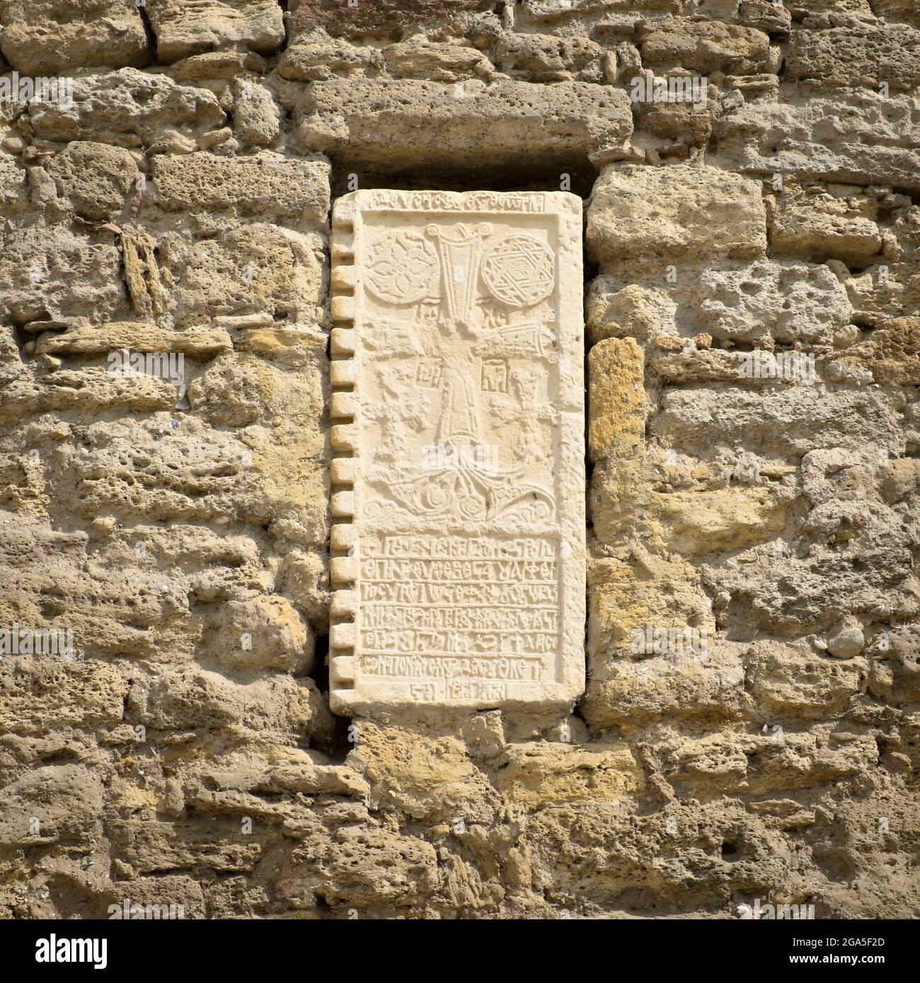 Tablette en argile avec symboles anciens sur le mur de pierre Banque D'Images